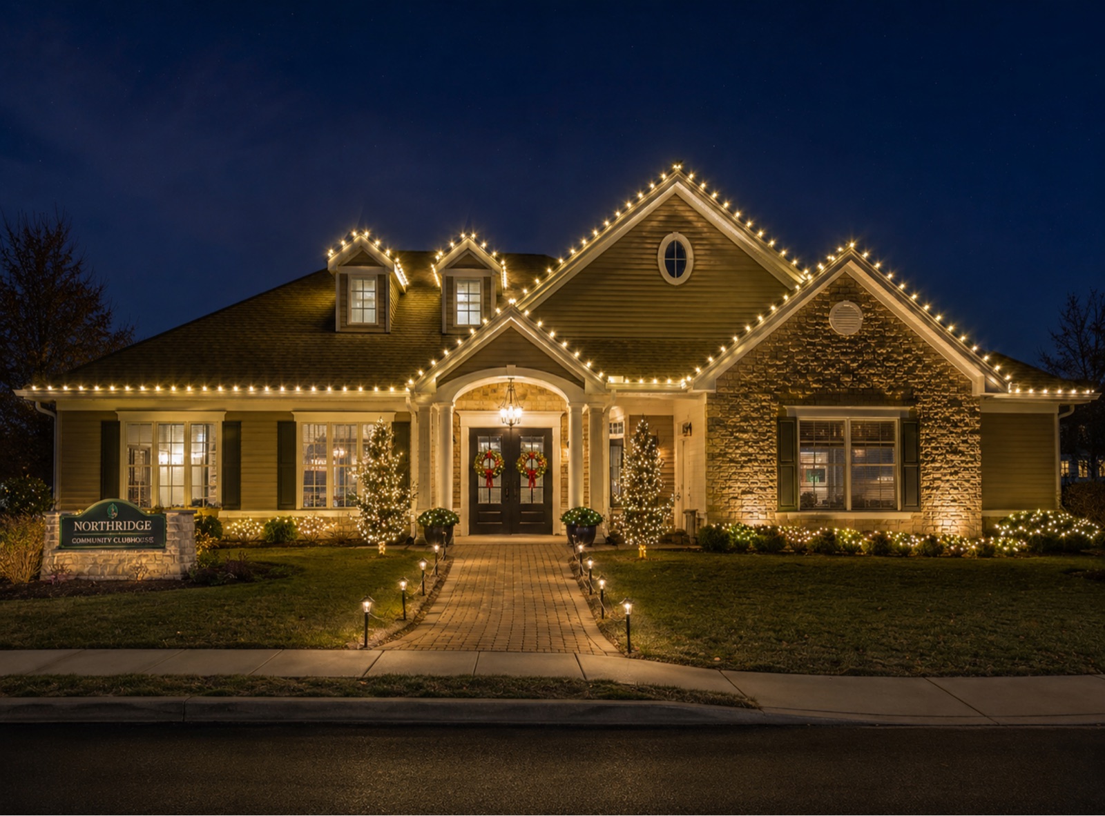 Northridge community clubhouse with warm holiday roofline lights